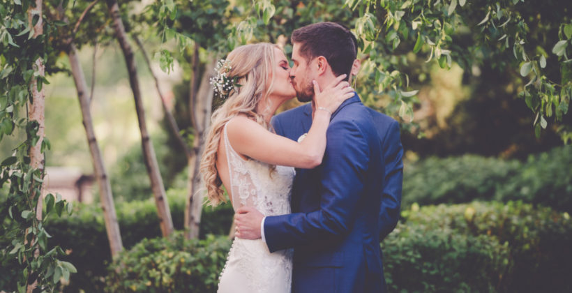 bride and groom kissing at alter